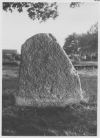 Runsten med kristen symbol på kyrkogården